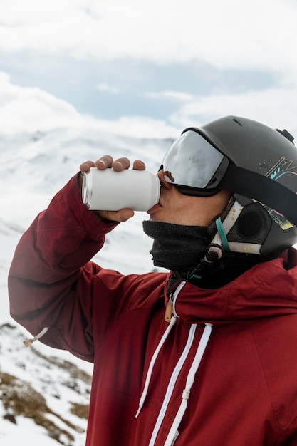 Schließen Sie oben Skifahrer, der Soda draußen trinkt