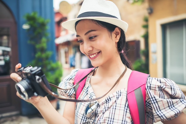 Schließen Sie oben vom jungen Hippie-Frauenrucksack, der Foto in städtischem nehmend macht.