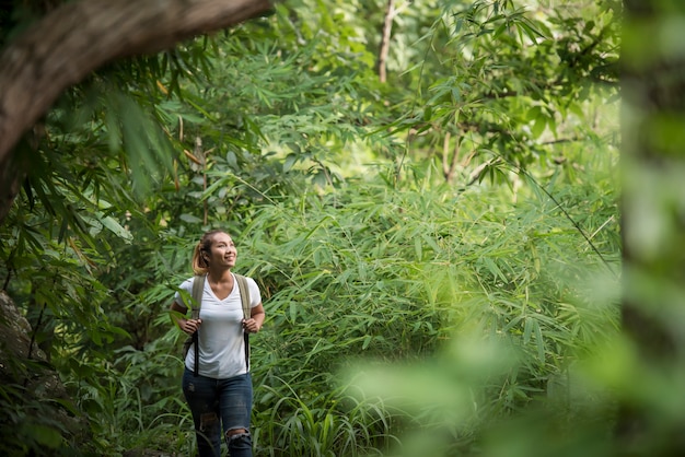 Schließen Sie oben vom jungen Wanderer, der durch den Wald geht, der mit Natur glücklich ist.