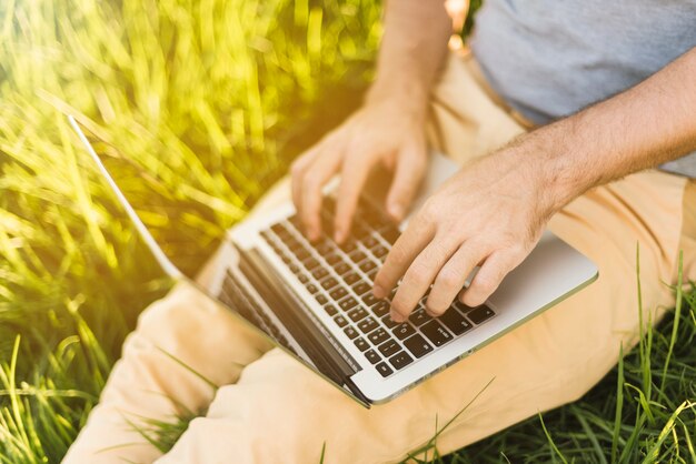 Schließen Sie oben vom Mann, der mit Laptop arbeitet