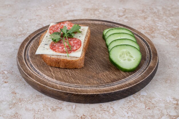 Schließen Sie oben vom Salamisandwich mit Gurkenscheiben