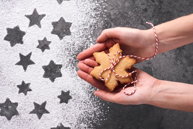 Schließen Sie oben von den Händen der Frau, die Lebkuchenplätzchen halten