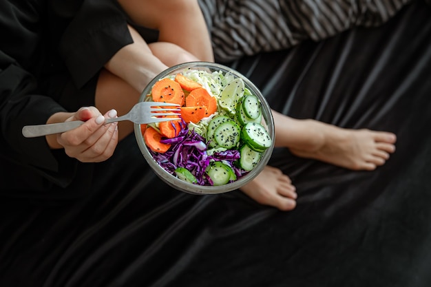 Schließen Sie oben von einer großen Schüssel mit frisch zubereitetem Gemüsesalat in weiblichen Händen.