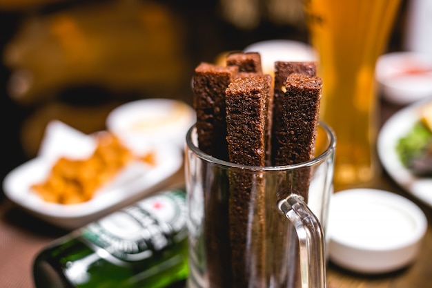 Schließen Sie Vorderansichtbiersnackcroutons von Schwarzbrot in einem Glas