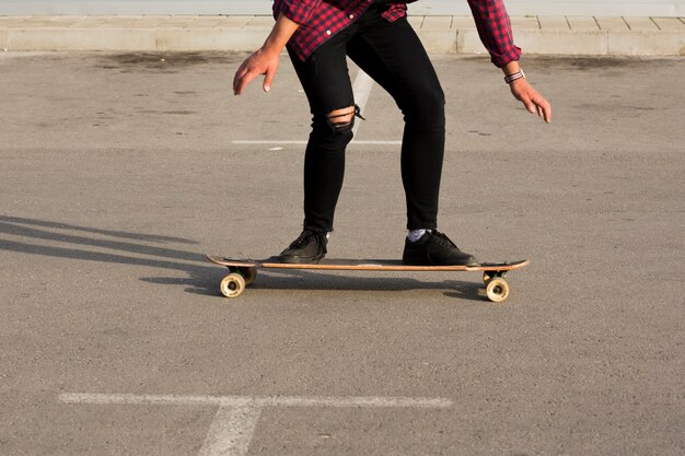 Kostenloses Foto schlittschuhläufer, der longboard auf asphalt reitet