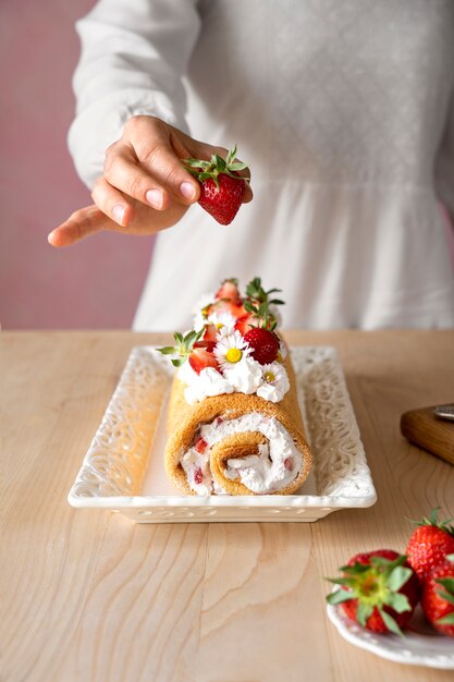 Schmackhafter Kuchen des hohen Winkels mit Erdbeeren auf Tisch