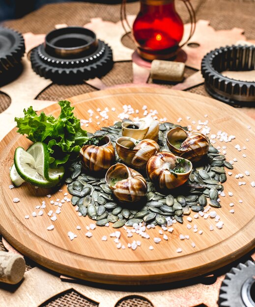 Schnecken auf Holzbrett Kürbiskerne Limettensalz Salz Seitenansicht