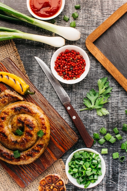 Kostenloses Foto schneckenwurst mit gemüse auf grauem hintergrund