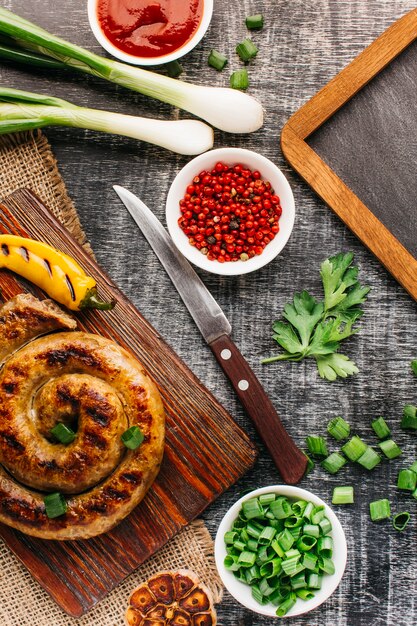 Schneckenwurst mit Gemüse auf grauem Hintergrund