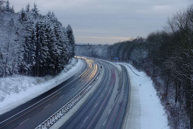 Schneebedeckte Autobahn in der Abenddämmerung in Deutschland