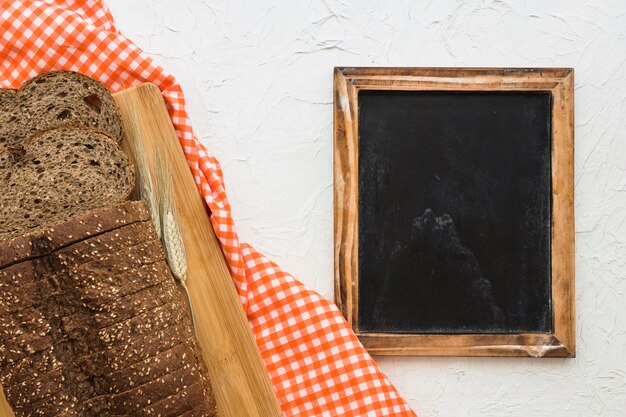 Schneiden Sie Brot und Stoff in der Nähe von Tafel