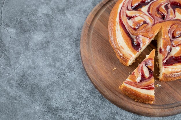 Schneiden Sie ein Stück Erdbeertorte auf einem Holzbrett.