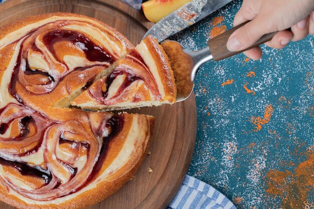 Schneiden Sie ein Stück Erdbeertorte auf einem Holzbrett.