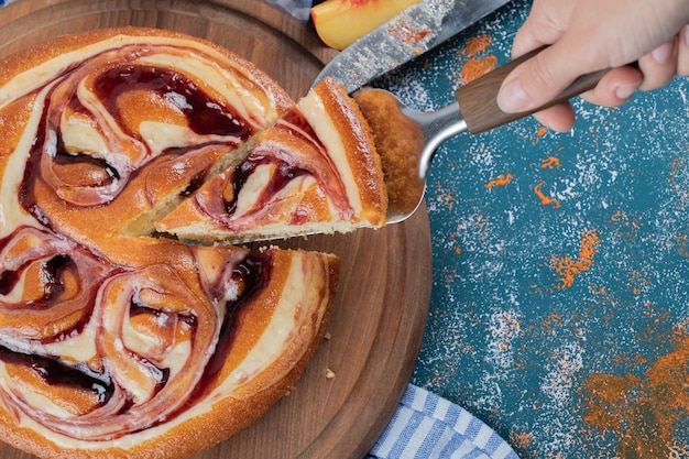 Schneiden Sie ein Stück Erdbeertorte auf einem Holzbrett.