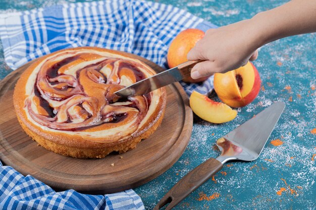 Schneiden Sie ein Stück Schokoladenkuchen auf einem Holzbrett