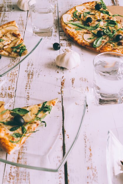 Schneiden Sie Pizzas auf weißer Tabelle