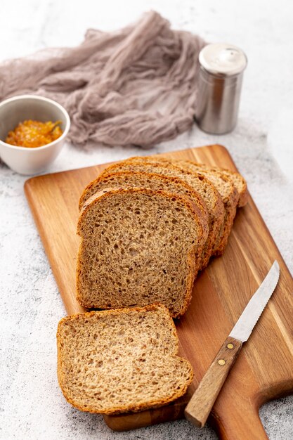 Schneiden Sie Scheiben brot auf hölzernem Brett mit Messer