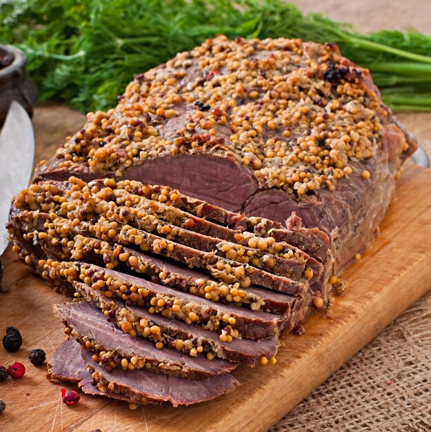 Schneiden Sie Stücke gebackenes Fleisch auf dem Tisch