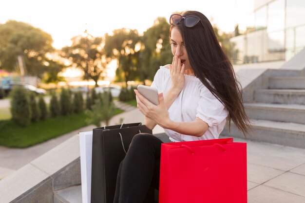 Schockierte Frau schaut auf ihr Handy