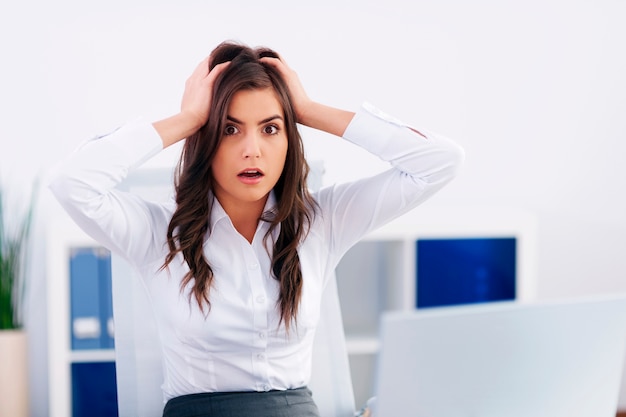 Schockierte junge Geschäftsfrau im Büro