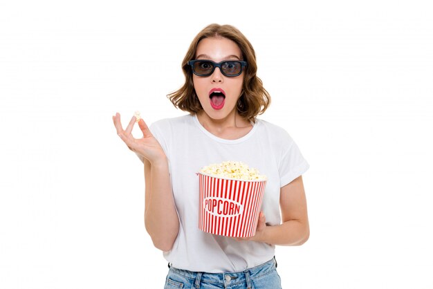 Schockierte kaukasische Frau, die Popcorn hält 3d Brille hält