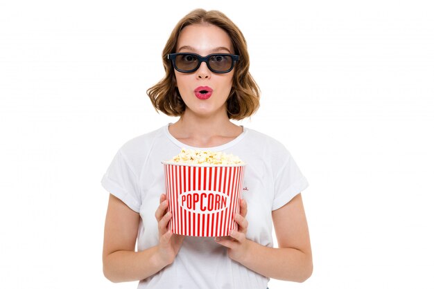 Schockierte kaukasische Frau, die Popcorn hält 3d Brille hält