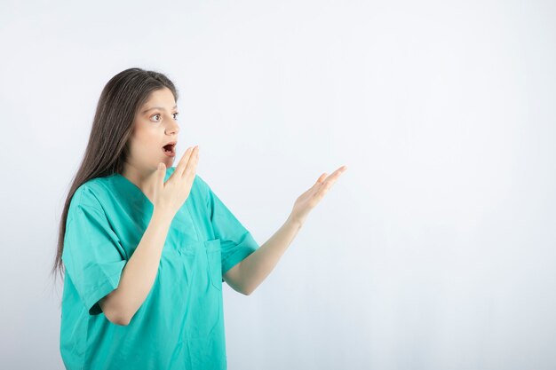 Schockierte medizinische Mitarbeiterin, die ihre Hand an den Mund hält.