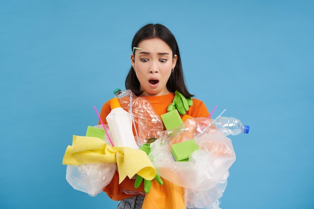 Kostenloses Foto schockierter umweltaktivist sammelt jede menge plastik zum recyceln und blickt verärgert auf flaschen und unsortierten müll