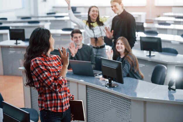 Schön dich zu sehen. Gruppe junger Leute in Freizeitkleidung, die im modernen Büro arbeiten