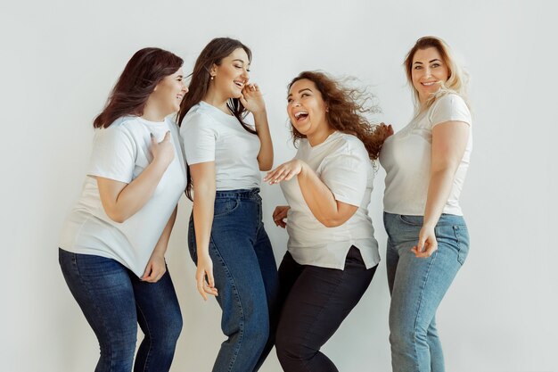 Schön. Junge kaukasische Frauen im lässigen Spaß zusammen. Freunde, die auf weißem Hintergrund posieren und lachen, sehen glücklich und gepflegt aus. Bodypositiv, Feminismus, sich selbst lieben, Schönheitskonzept.