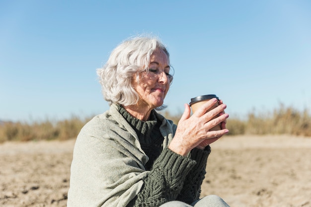 Kostenloses Foto schöne ältere dame, die kaffee hält