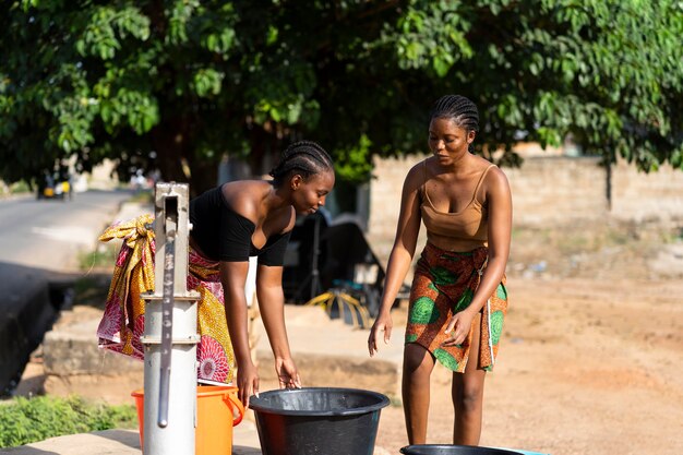 Schöne afrikanische Frauen, die Wasser holen