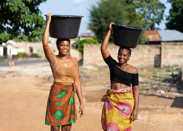 Schöne afrikanische Frauen, die Wasser holen