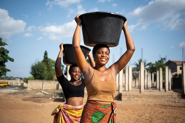 Kostenloses Foto schöne afrikanische frauen, die wasser holen