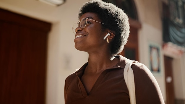 Schöne Afro-Amerikanerin mit lockigem Haar, die eine glückliche Liste sieht