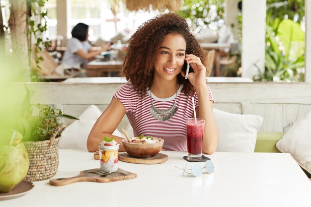 Schöne afroamerikanische Frau im Café