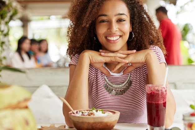 Schöne afroamerikanische Frau im Café