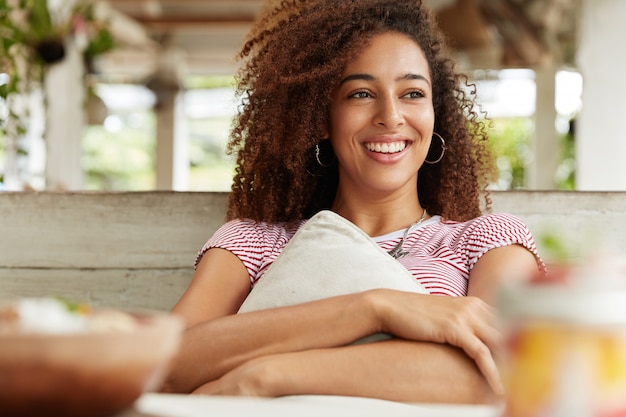 Schöne afroamerikanische Frau im Café