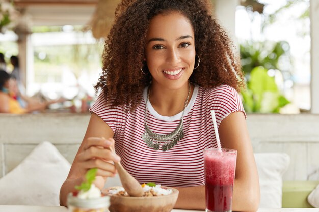 Schöne afroamerikanische Frau im Café