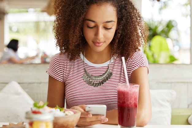 Schöne afroamerikanische Frau im Café