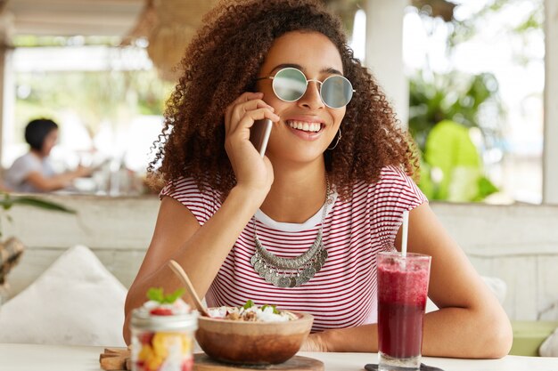 Schöne afroamerikanische Frau im Café