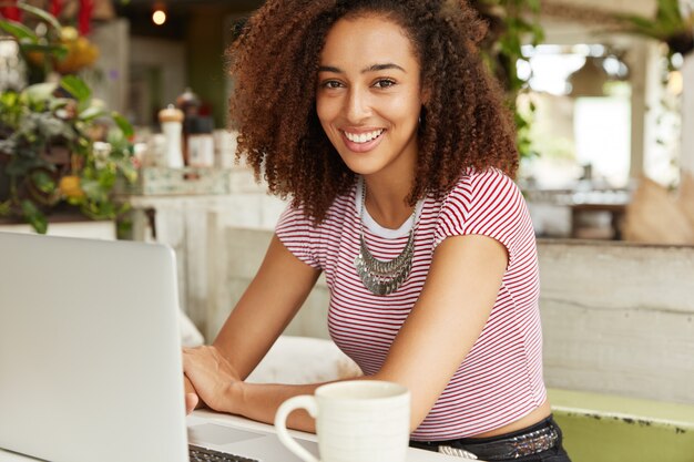 Schöne afroamerikanische Frau im Café