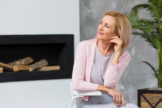 Schöne alte aufwerfende Dame beim weg schauen