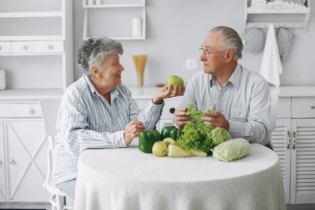 Schöne alte Paare bereiten Lebensmittel in einer Küche zu