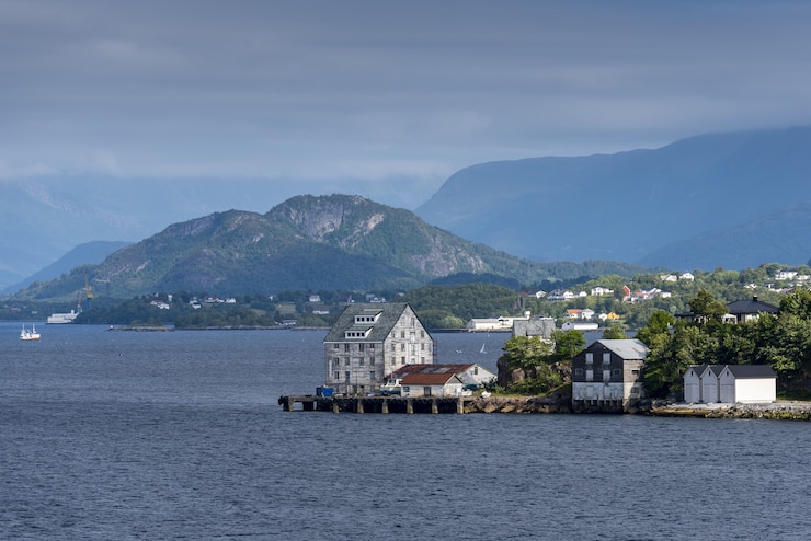 Kostenlose Foto schöne ansicht der gebäude am ufer nahe alesund, norwegen mit hohen bergen