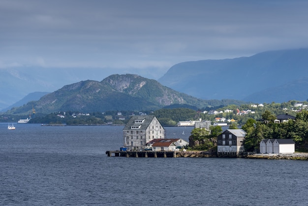 Schöne Ansicht der Gebäude am Ufer nahe Alesund, Norwegen mit hohen Bergen