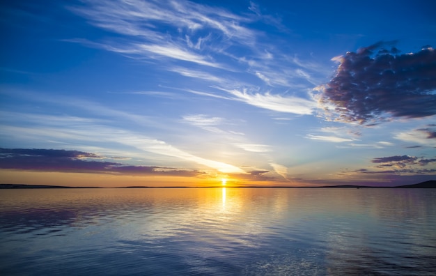 Schöne Ansicht des Meeres mit der Sonne, die in einem blauen Himmel im Hintergrund scheint