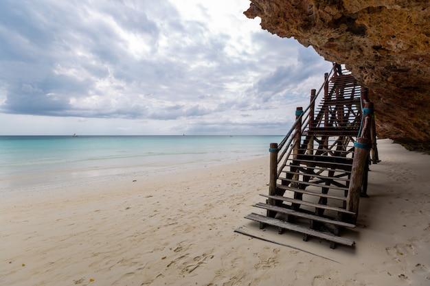 Schöne Ansicht einer Holztreppe am Strand durch den Ozean gefangen genommen in Sansibar, Afrika