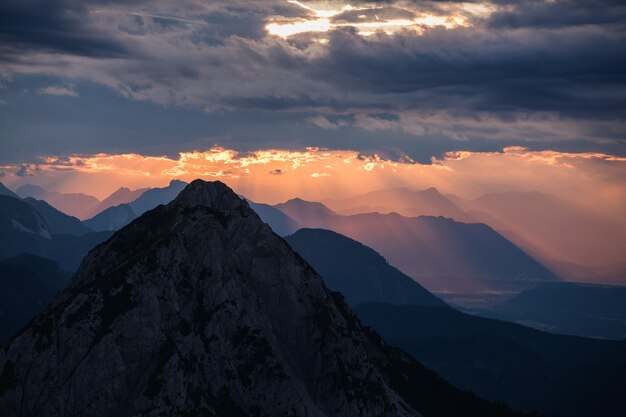 Schöne Ansicht einer Silhouette der Berge unter dem bewölkten Himmel während des Sonnenuntergangs