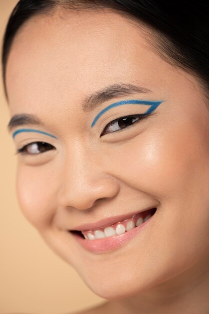 Schöne asiatische Frau, die blauen Eyeliner trägt